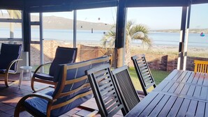 A covered outdoor seating area with a view of the beach and sea. - Seemansrust, Langebaan 9-sleeper (Langebaan)