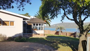 A modern house with a paved driveway, a glass door entrance, and a view of the sea. - Seemansrust, Langebaan 9-sleeper (Langebaan)