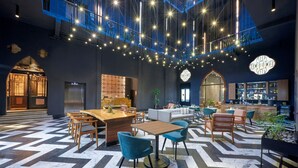 A spacious lobby with a high ceiling, modern lighting, and a bar area. - City Centro by Marriott Ciudad De México (Mexico City)