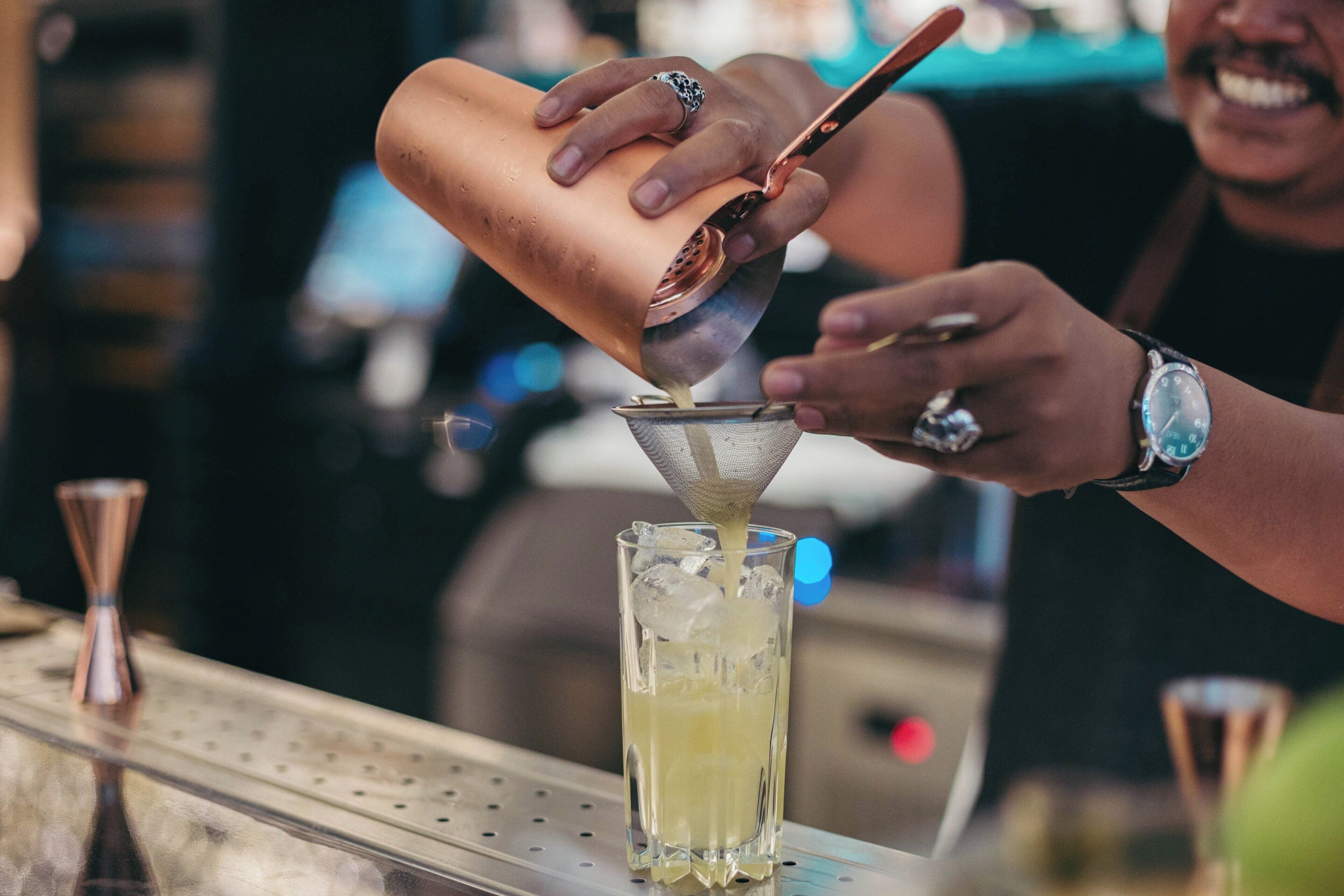 A person pouring a drink into a glass.