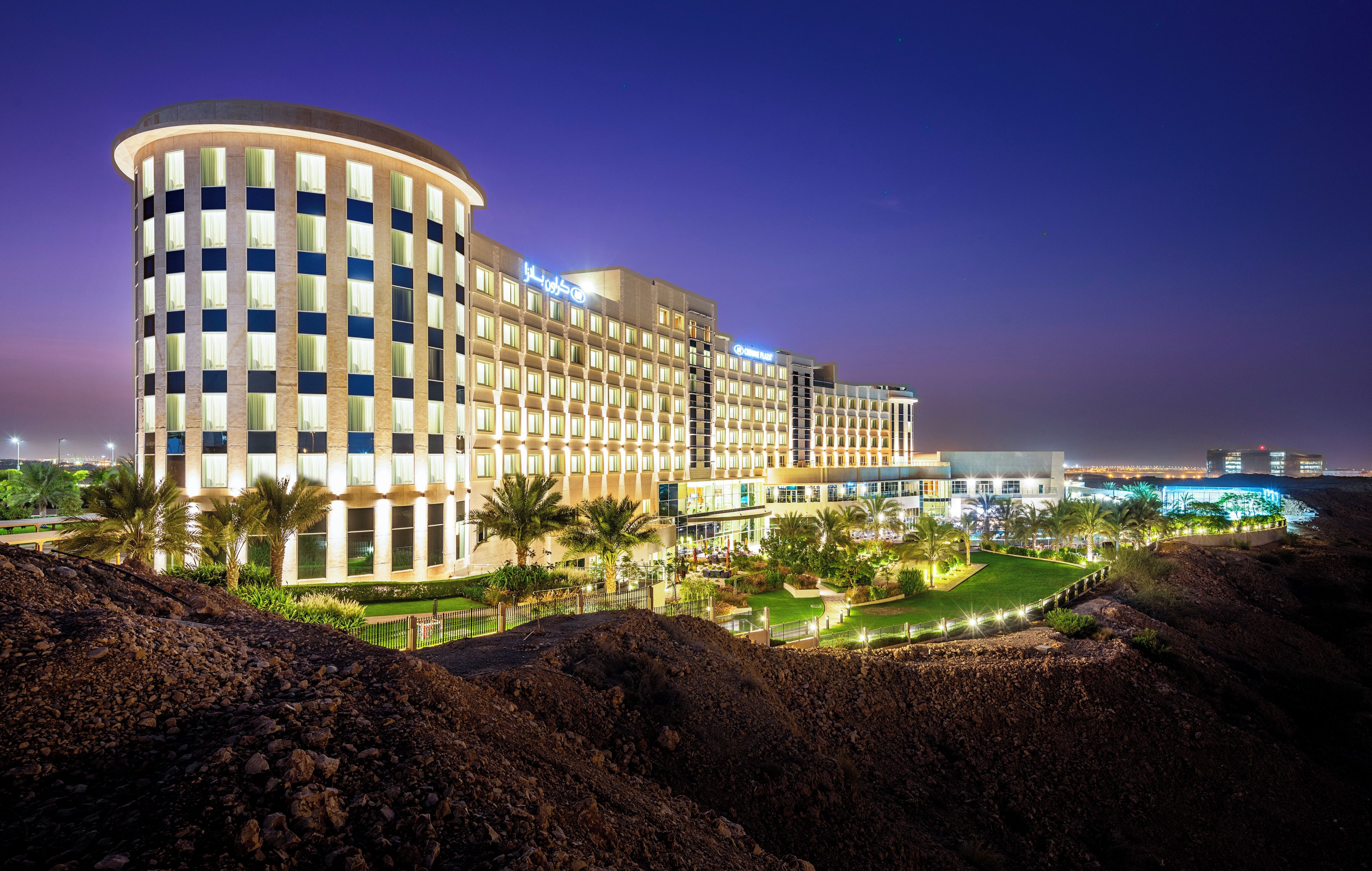 A multi-story hotel with a curved facade, large windows, and a well-lit entrance area.