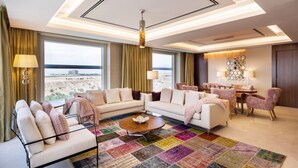 Un salón amplio con un ventanal grande, una mesa de centro y un comedor con sillas y una mesa.