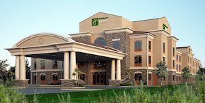A Holiday Inn Express hotel with a covered entrance, stone facade, and multiple windows. - Holiday Inn Express & Suites Redding by IHG (Redding)