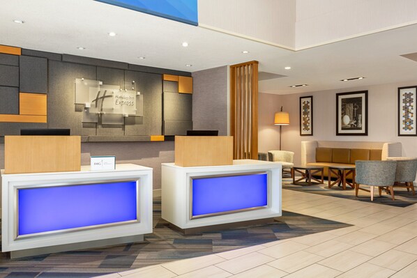 A modern hotel lobby with reception desks, seating area, and artwork on the walls. - Holiday Inn Express & Suites Redding by IHG (Redding)
