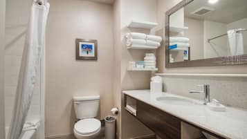 A modern bathroom with a toilet, sink, and shower area.