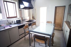A compact kitchen with a central island, a microwave, a toaster, and a sink. - WORLDTRECK DINER & GUESTHOUSE - Pise - Hostel (Nagano)