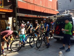 A group of cyclists gathered around a van, with bicycles and gear visible. - WORLDTRECK DINER & GUESTHOUSE - Pise - Hostel (Nagano)