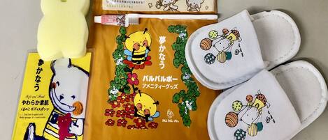 A set of slippers with a bear design, a body sponge, and a yellow package with a bear illustration.