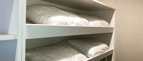 Una cama litera con dos niveles, cada uno con una almohada y una bolsa de plástico.