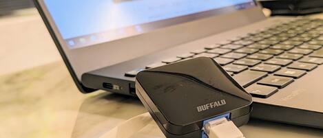 Una laptop con un cargador Buffalo conectado.