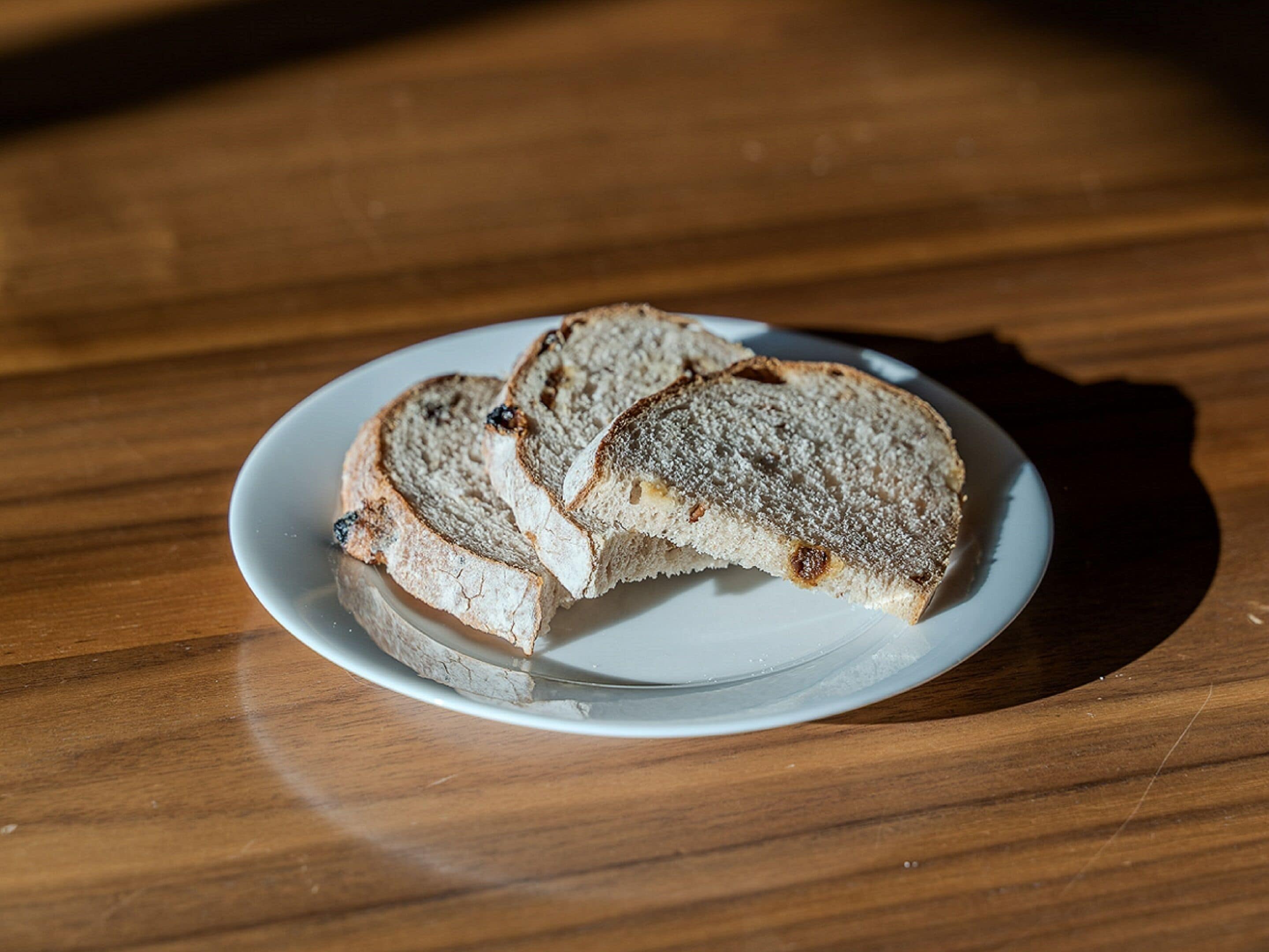 Broodsneden op een wit bord op een houten tafel.