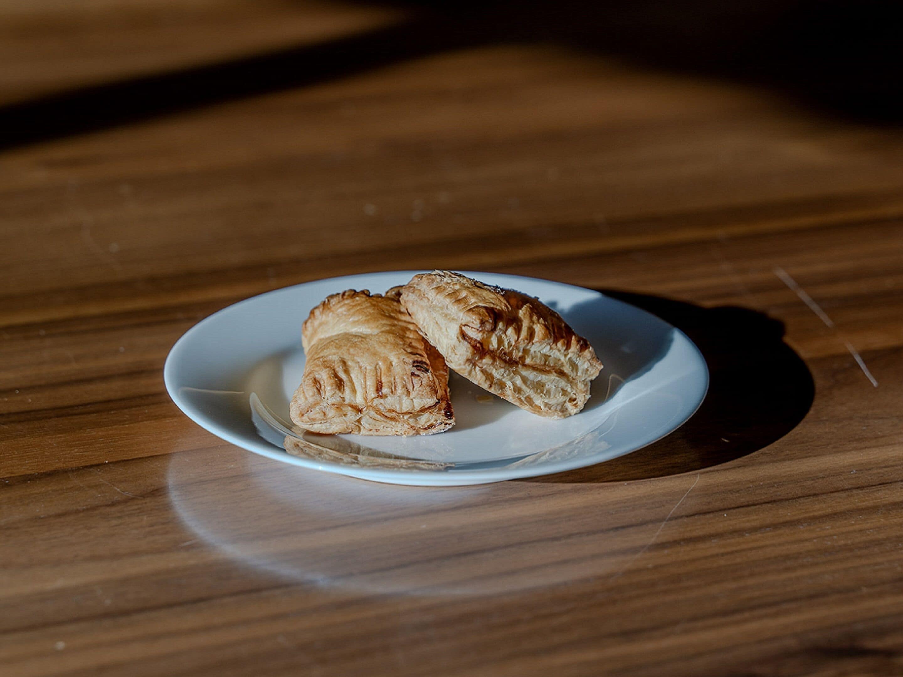 A plate with two pastries on a wooden table.