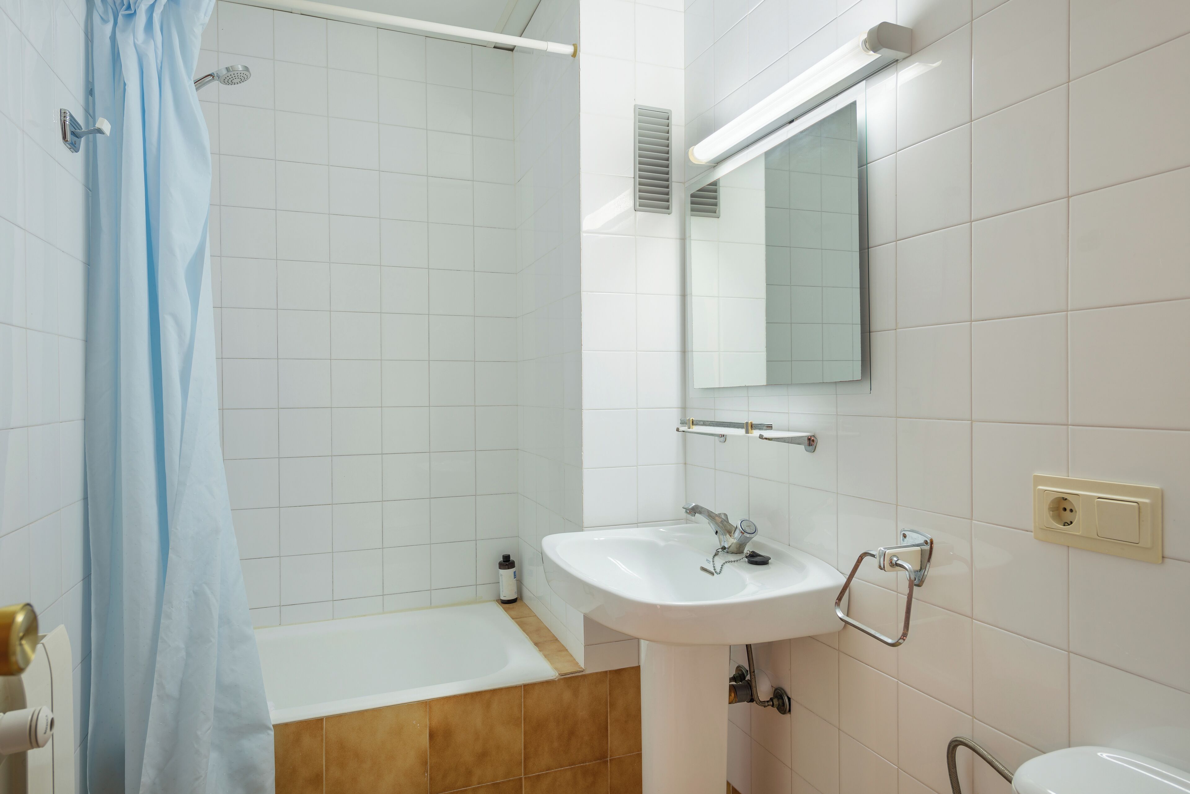 A modern bathroom with a shower, a sink, and a toilet.