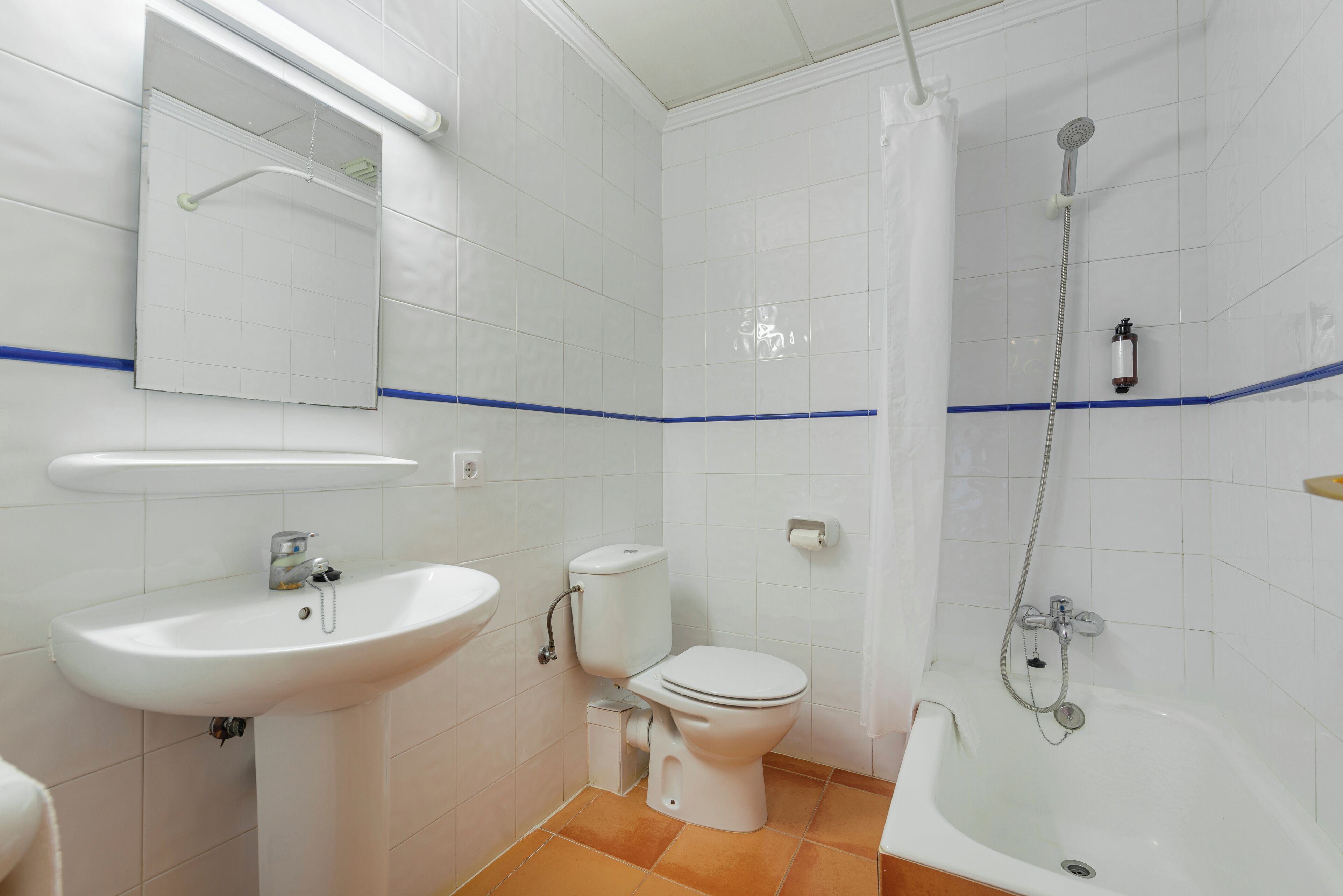 Een badkamer met een wastafel, toilet en bad.