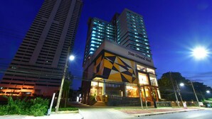 Een modern hotelgebouw met een geometrisch gevelontwerp en verlichte signage.