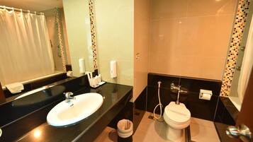 Un baño moderno con lavamanos de encimera negro, espejo, inodoro y ducha.