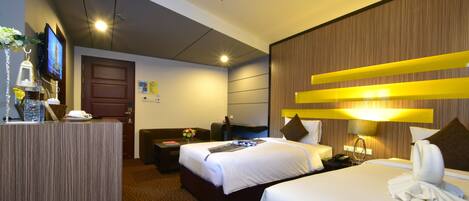 A hotel room with a large bed, a desk, a TV, and a bathroom.