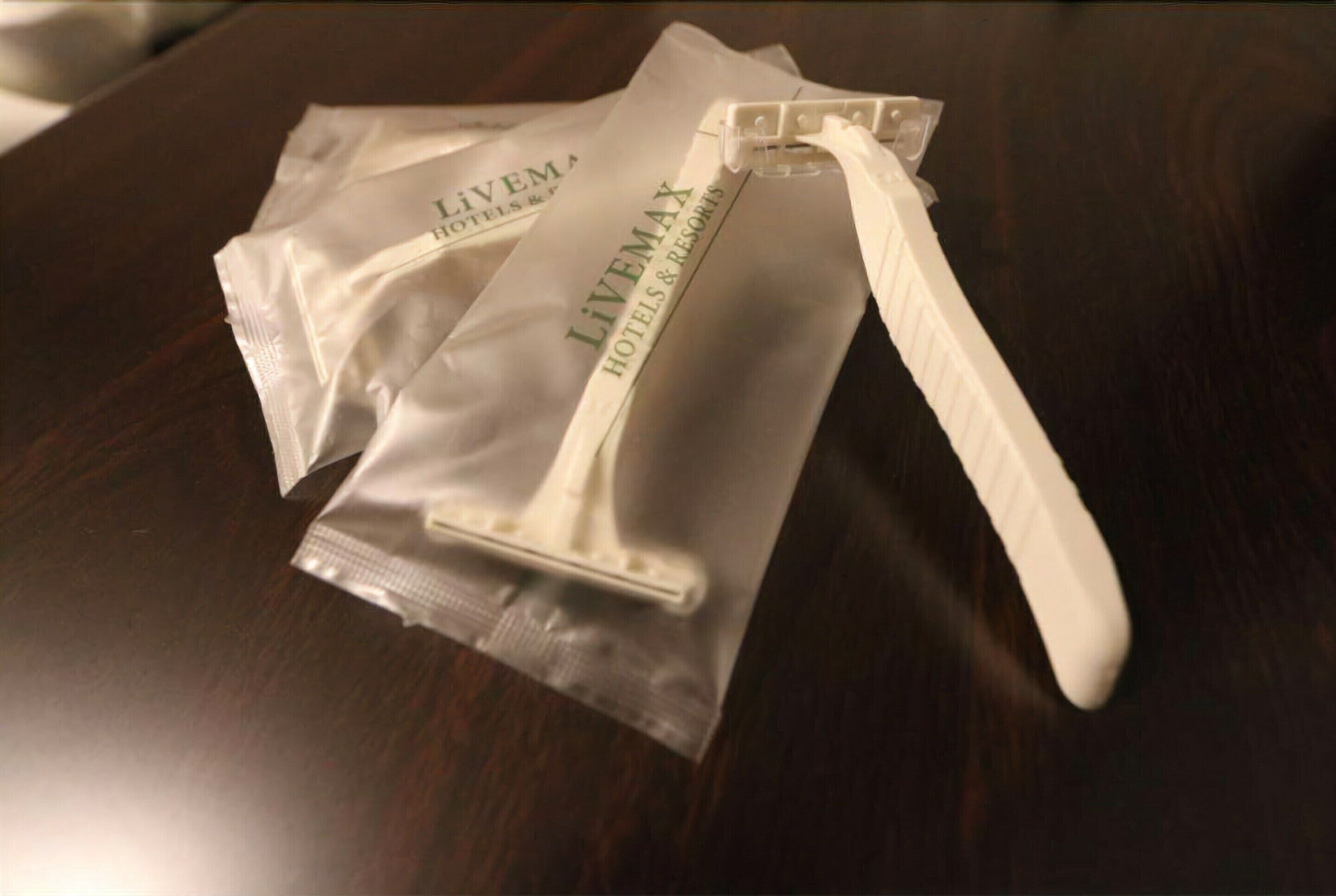 A white plastic bag with the text "LIVEMAX HOTELS & RESORTS" on a wooden surface.