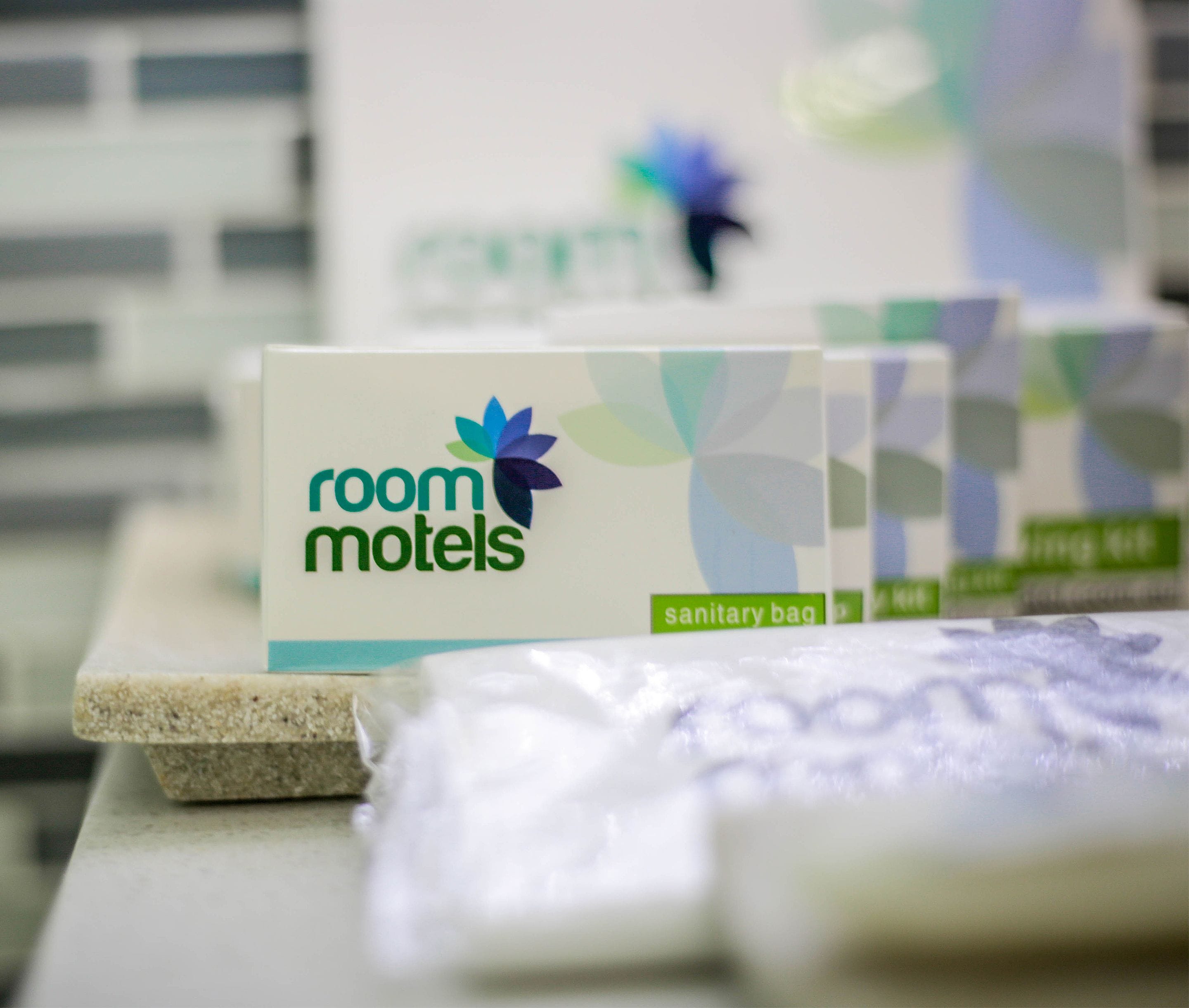 Exhibición de bolsas sanitarias de marca para habitaciones de motel.