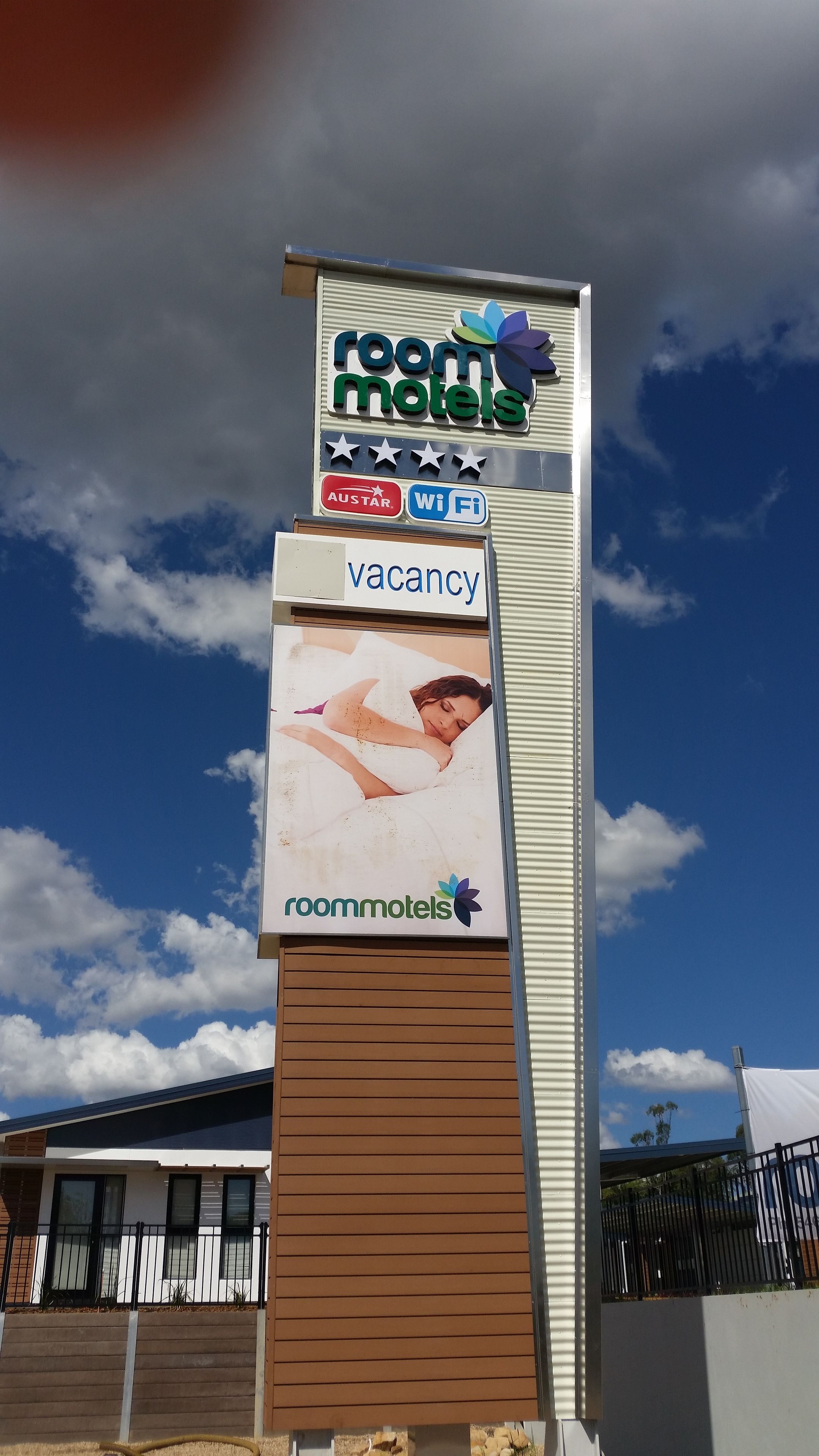 A signboard for Room Moteis with a vacancy notice, Wi-Fi symbol, and AUSTAR logo.