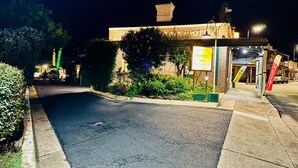 Un motel con fachada de ladrillo, un letrero y una entrada bien iluminada.
