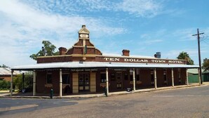 Un edificio de dos pisos con un letrero que dice 'Ten Dollar Town Hotel'.