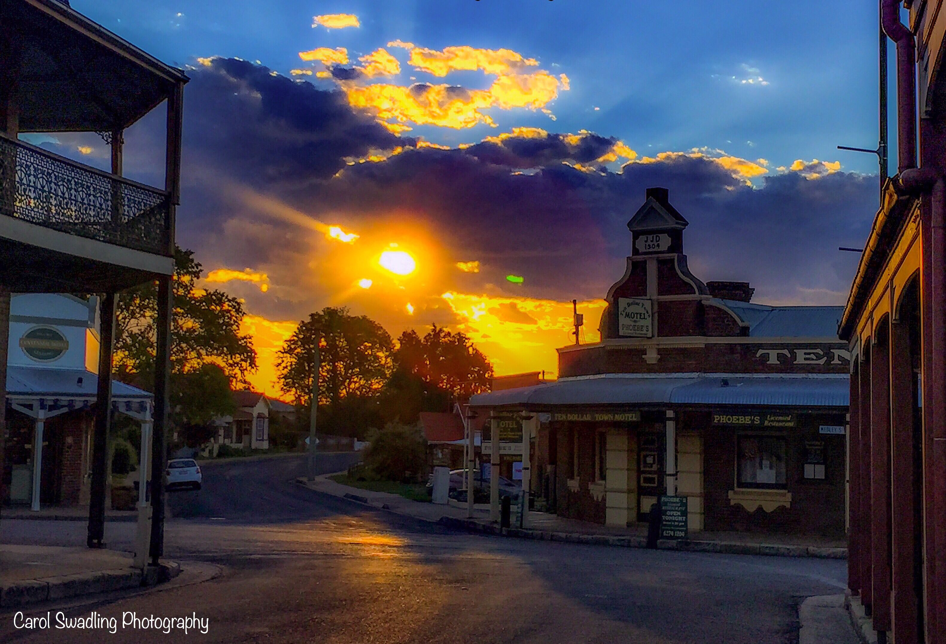 A sunset over a town with a motel and a restaurant.