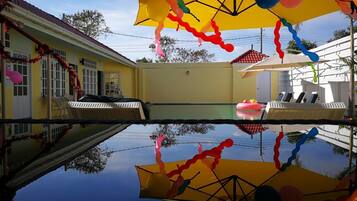 Una piscina al aire libre, tumbonas