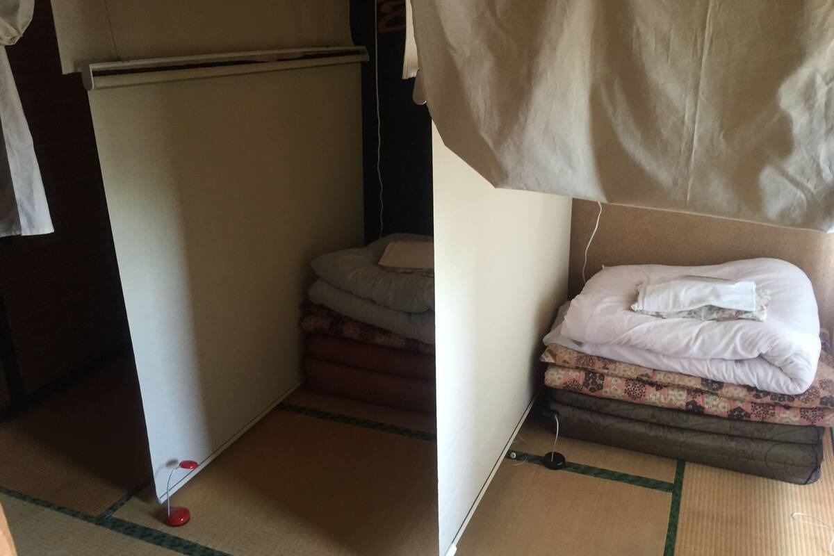 Une petite pièce comprenant un lit, une petite table et une chaise.