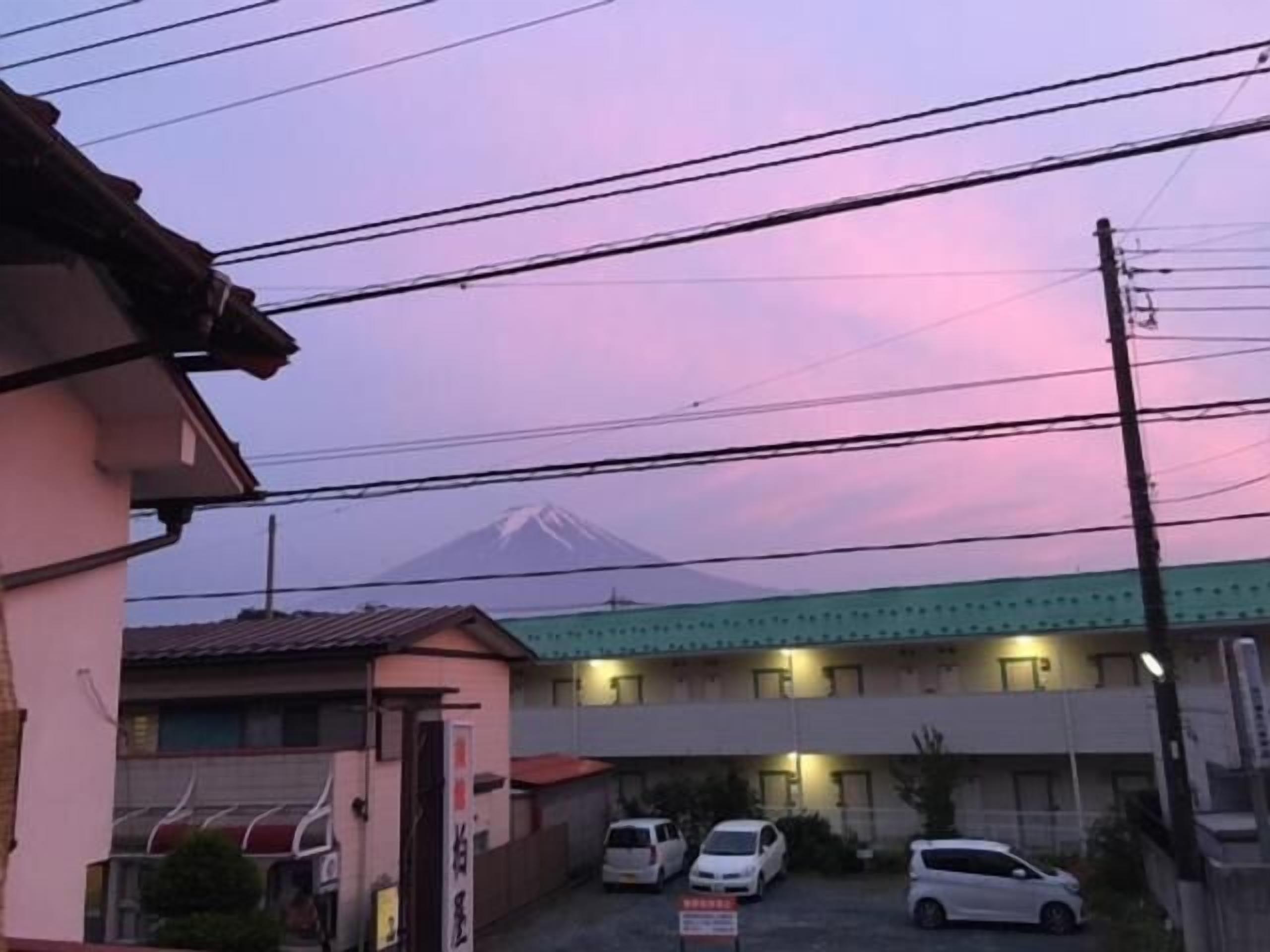 Edificio con zona de estacionamiento y vista a la montaña.