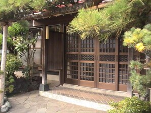 A traditional Japanese gate with a tiled pathway leading to a wooden building. - Wafu Guesthouse Kashiwaya - Hostel (Fujikawaguchiko)