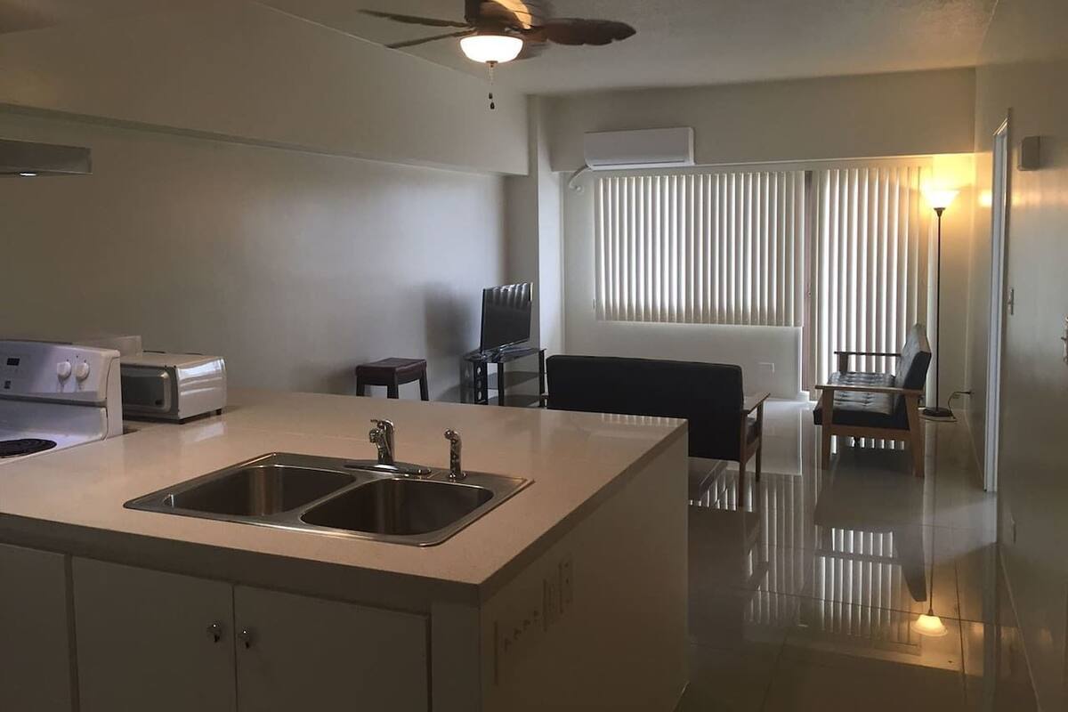 A modern kitchen with a central island, a ceiling fan, and a dining area with a table and chairs.