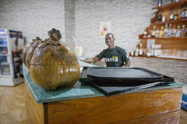 A wooden counter with a large ceramic jug and a black tray. - Karela Beach Resort (Beyin)