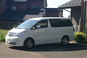 A white minivan parked in a driveway. - Villa May Queen (Fujikawaguchiko)