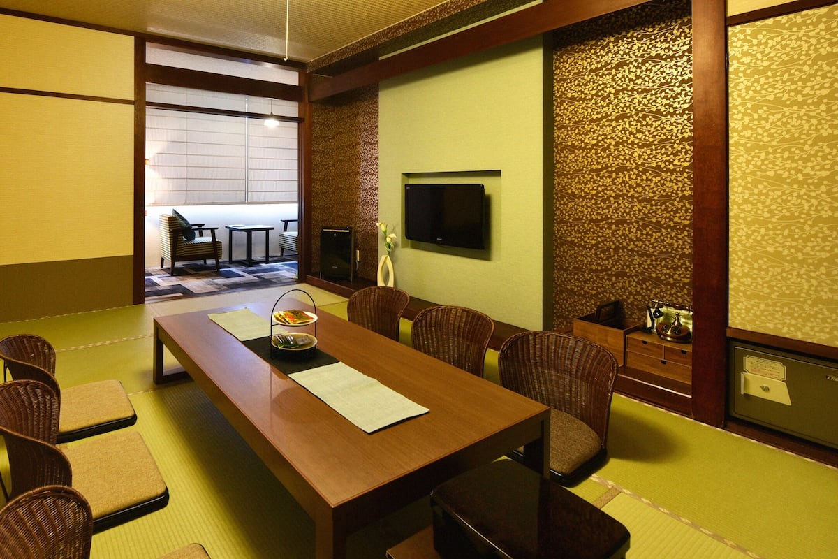 A traditional Japanese-style room with tatami flooring, a low wooden table, and tatami mat seating.
