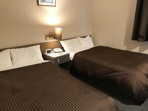 A hotel room with two beds, a nightstand with a lamp, a clock, and a phone. - Hotel Avan Sukumo (Sukumo)