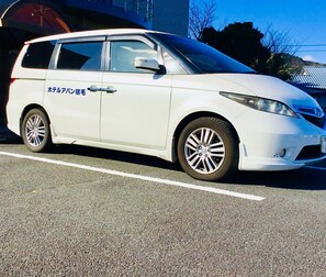 A white station wagon parked on a road with a visible license plate. - Hotel Avan Sukumo (Sukumo)