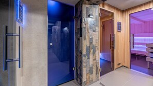 A modern hotel lobby with a stone wall, a blue-lit door, and a wooden reception area.