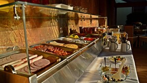 A buffet with various food options and utensils.