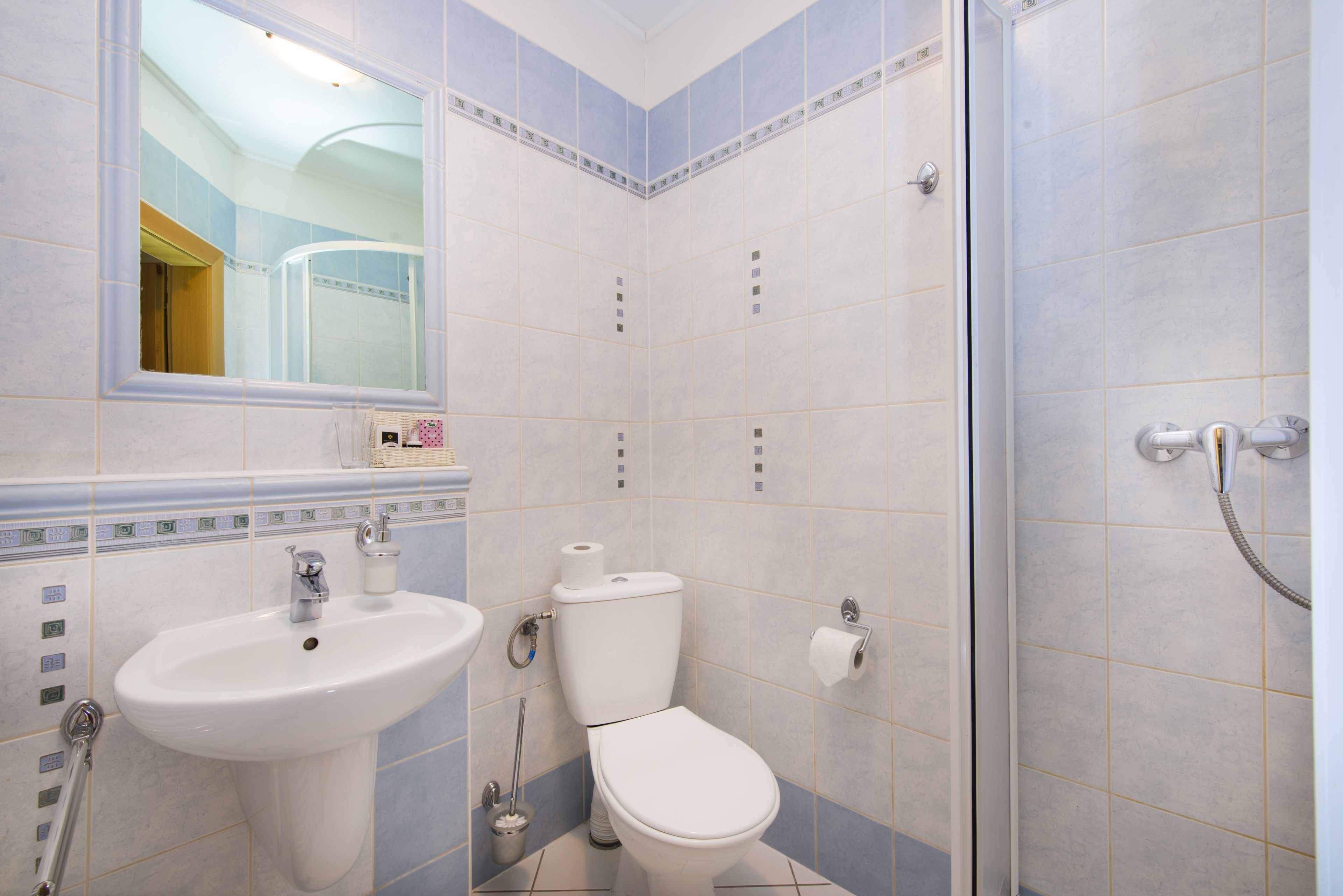 A bathroom with a sink, toilet, and shower.