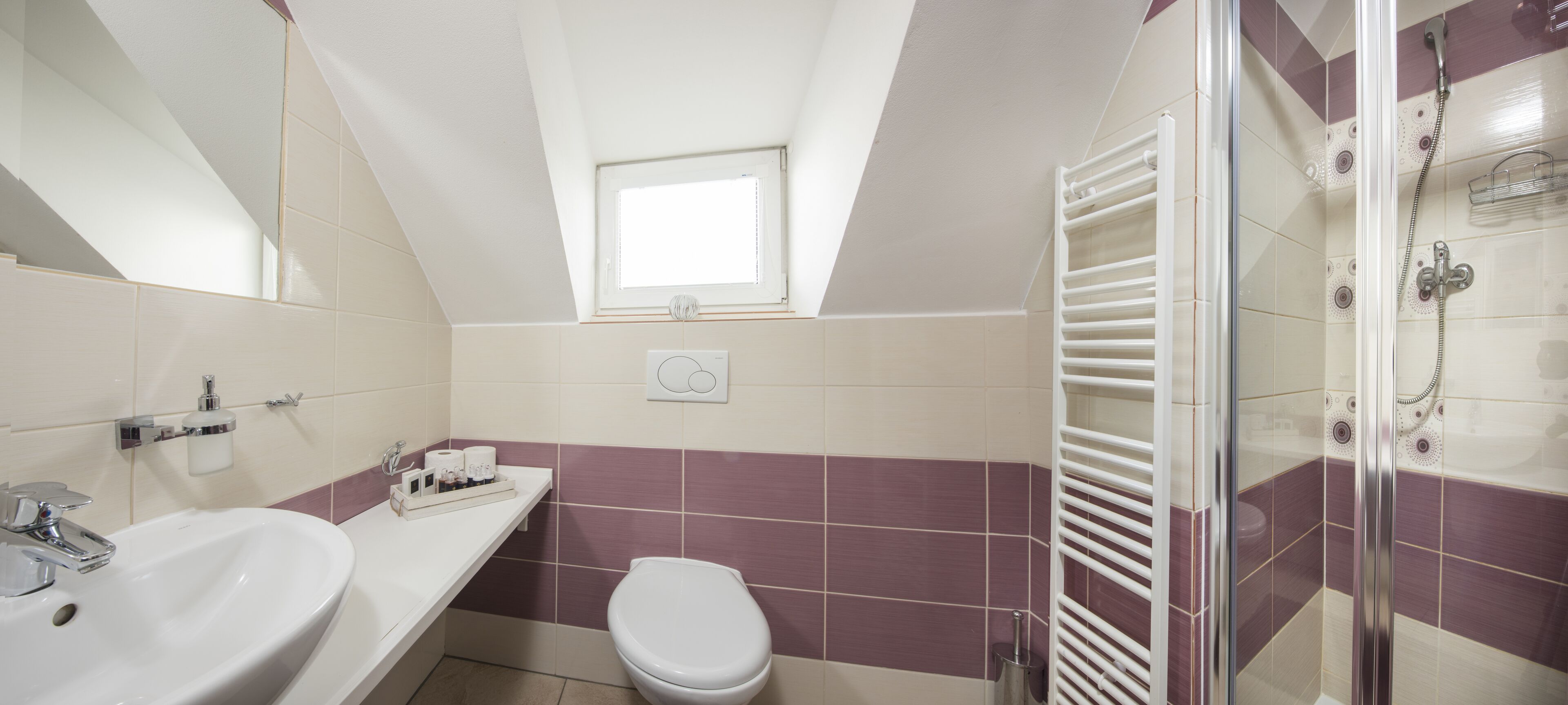 A bathroom with a white sink, a toilet, and a shower area.