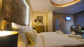 A hotel room with a large bed, a bedside lamp, a dresser, a mirror, and a television on the wall.