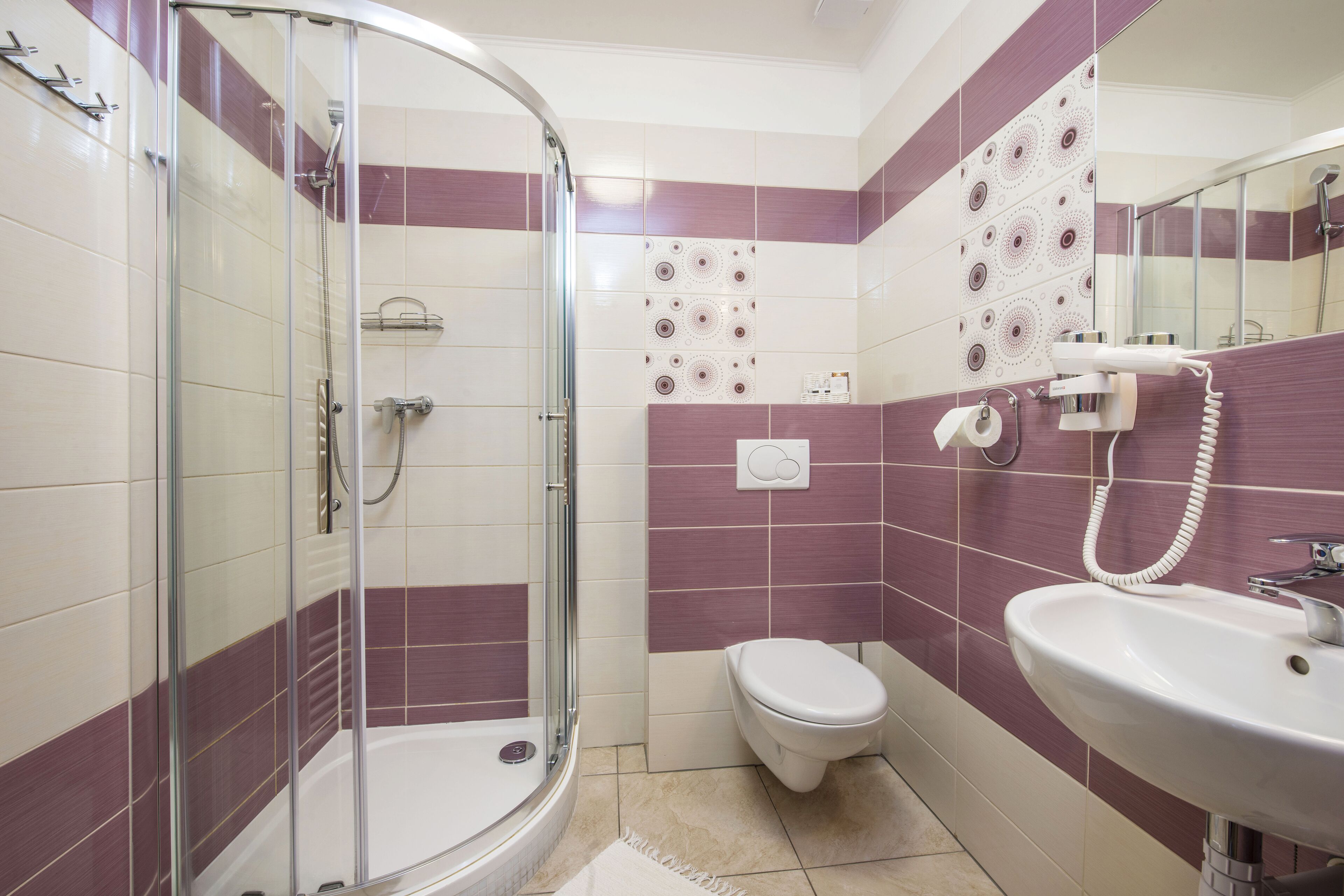 A bathroom with a glass-enclosed shower, a white toilet, and a sink with a mirror.