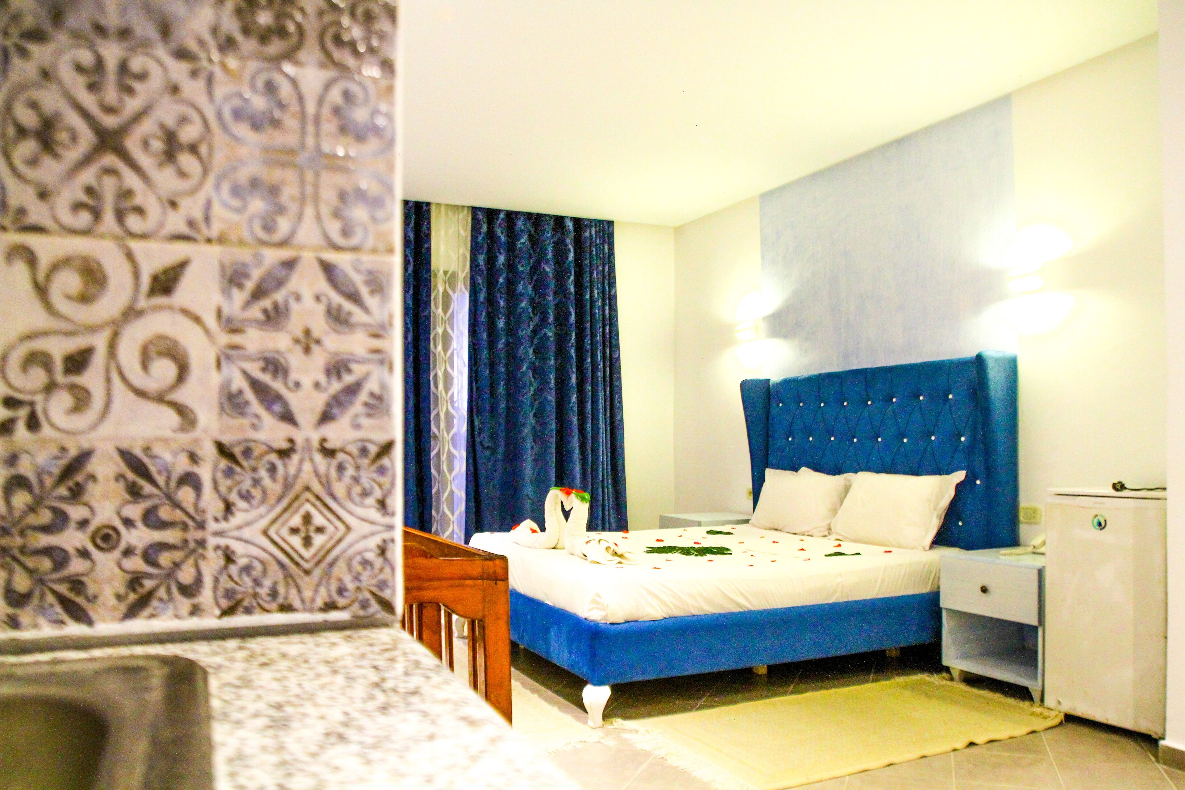 A bedroom with a bed, nightstand, and a bathroom area.