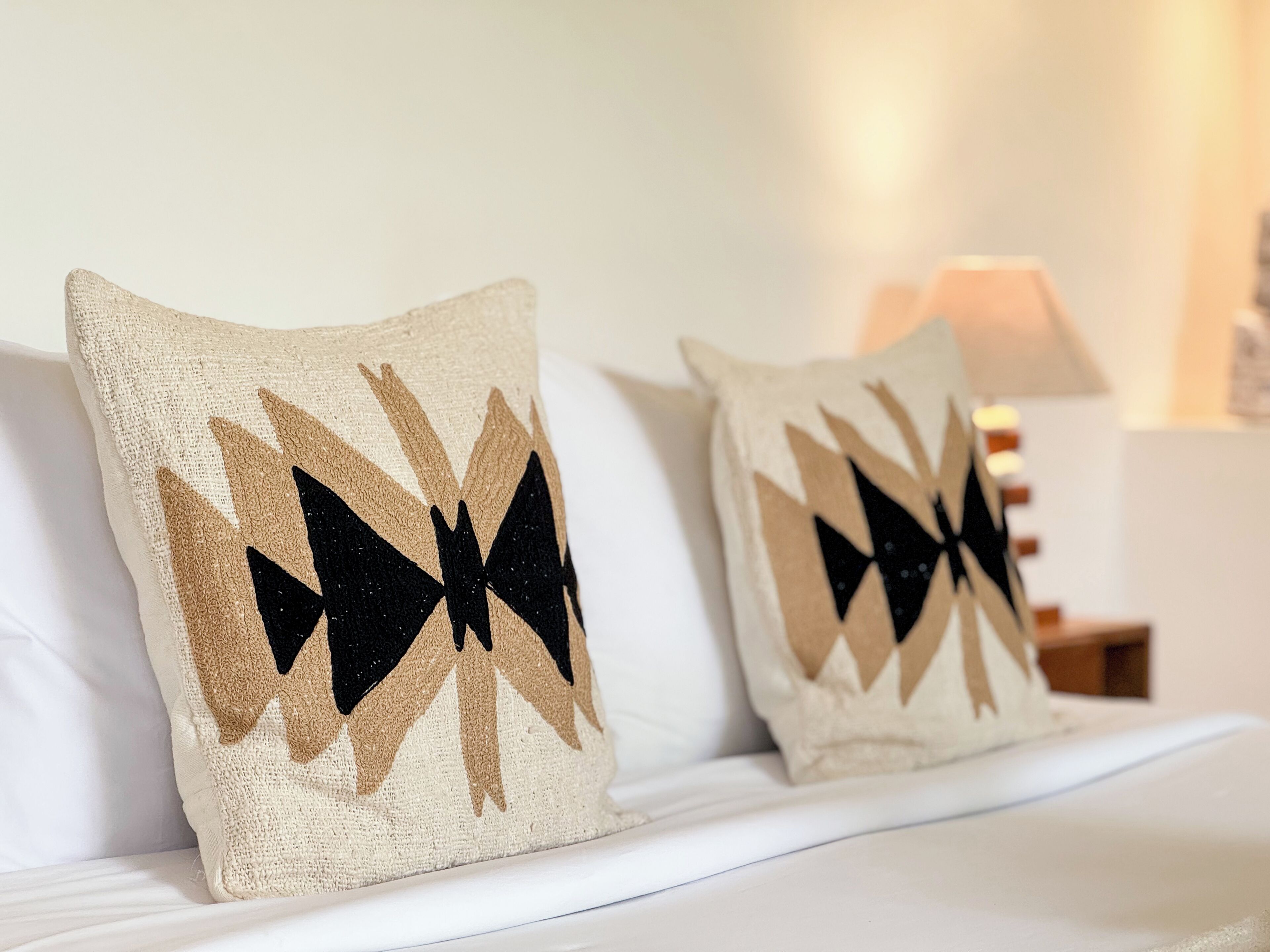 Two pillows with a geometric pattern on a bed.