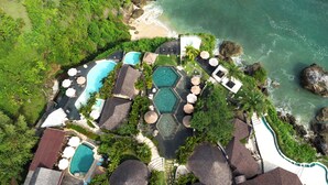An aerial view of a resort with multiple swimming pools, a beach, and lush greenery. - Biu Biu Resort Bali  (Jimbaran)