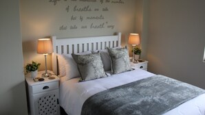 A neatly made bed with a grey blanket, two bedside lamps, and a wall with a motivational quote. - Golf Paradise, Langebaan 6-sleeper (Langebaan)