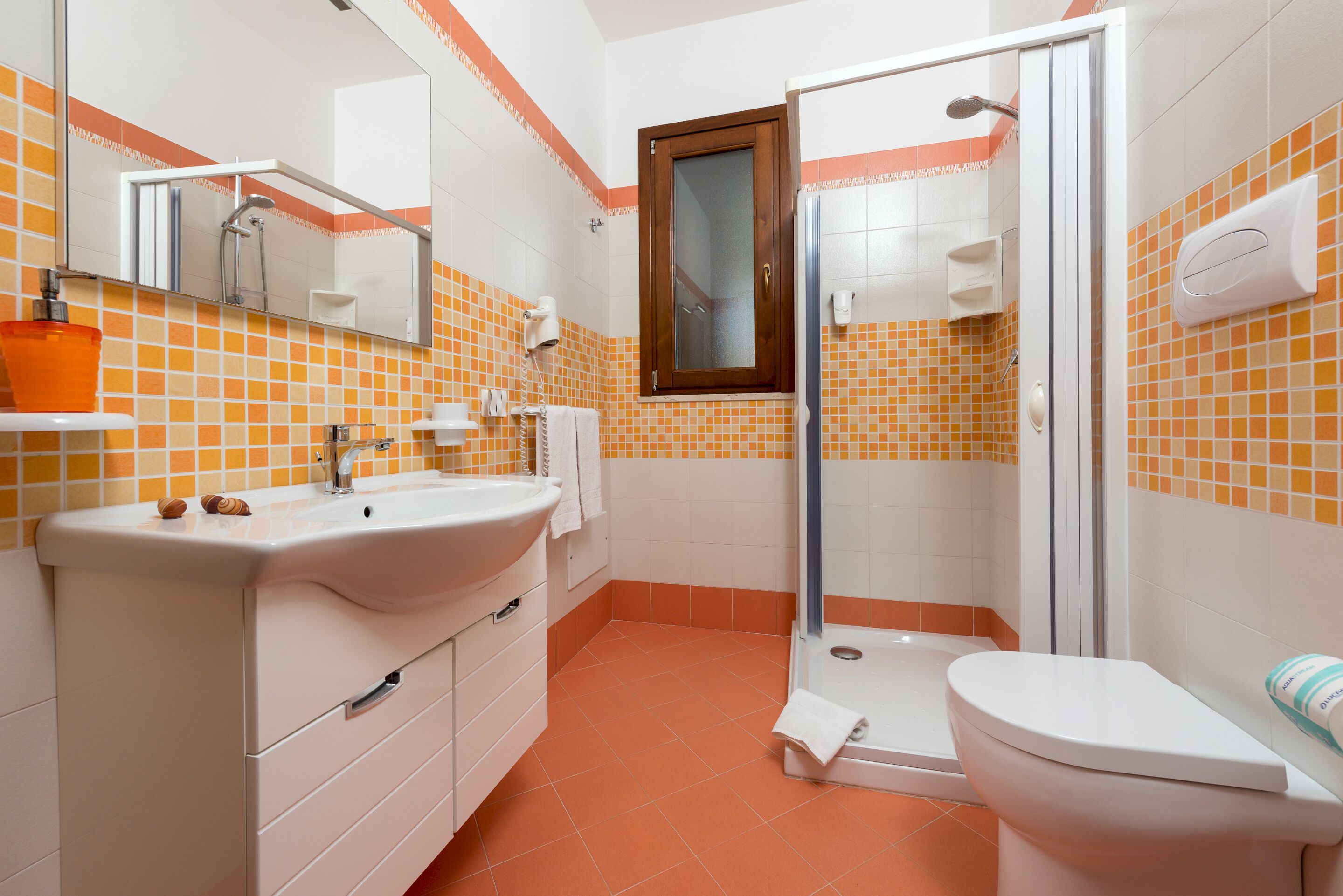 A bathroom with a white sink, a glass shower enclosure, and a toilet.