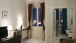 A hotel room with a TV, lamp, and a bed. - Koro de Varsovio - Chmielna 6 (Warsaw)