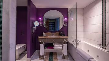 A modern bathroom with a vanity, sink, and bathtub.